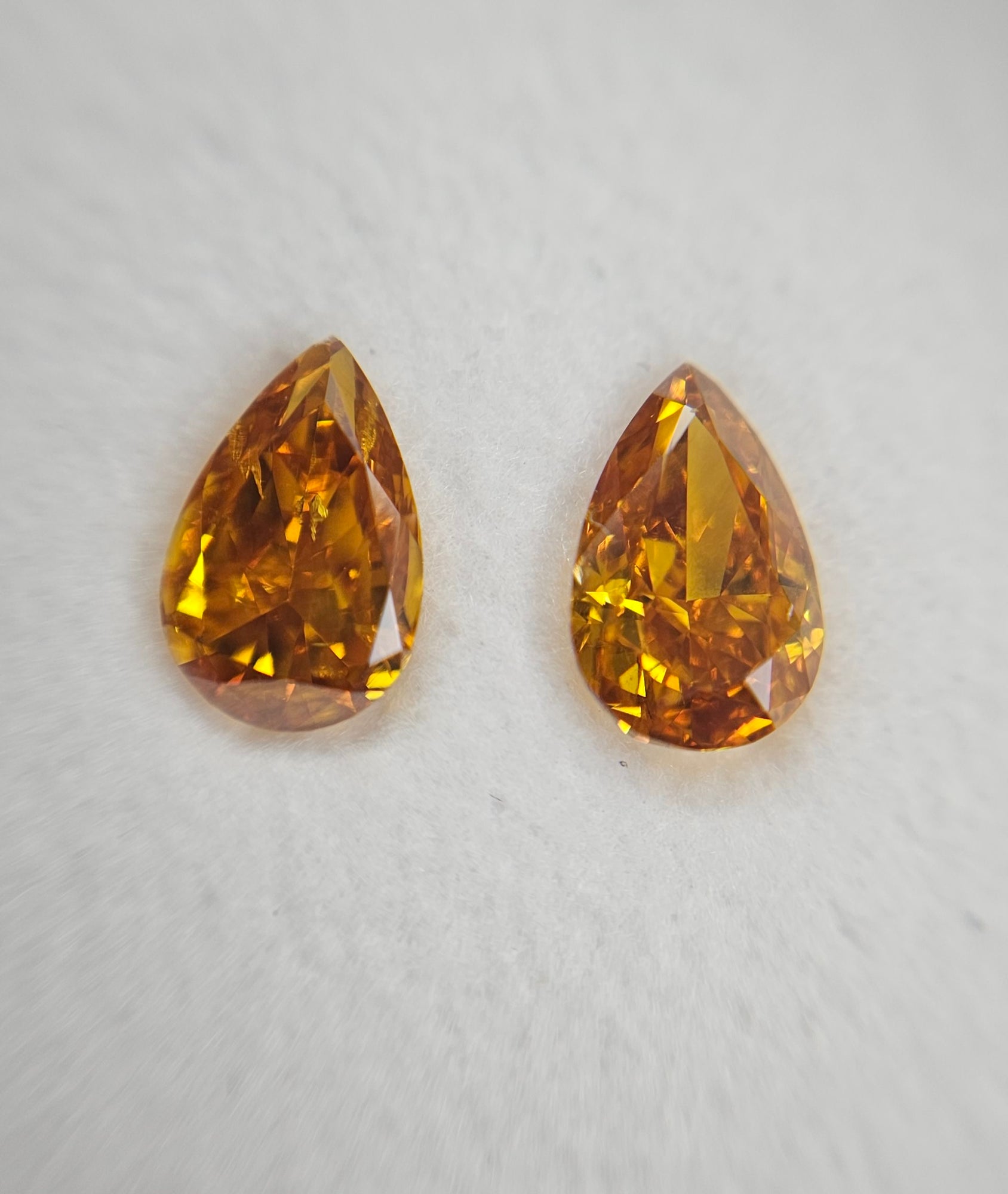 Yellowish orange diamonds, 0.48 & 0.44 carats, pear shape